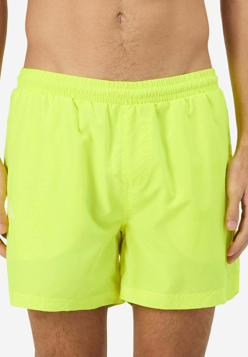 Shorts de bain jaune fluo en matériau léger, avec une taille élastique et une texture lisse, au design simple et sans motifs.