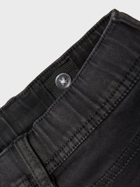 Jeans en denim noir avec fermeture à bouton et tissu texturé. Comprend une taille avec passants de ceinture et des détails de couture contrastés.