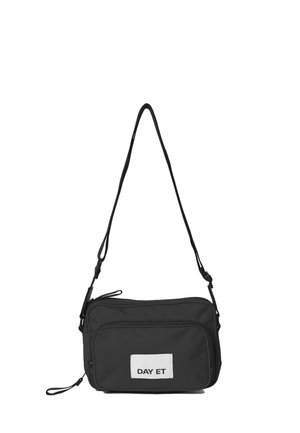 Sort nylon crossbody taske med rektangulær form, justerbar rem, to lynlåslommer og et hvidt skilt med "DAY ET" tekst.