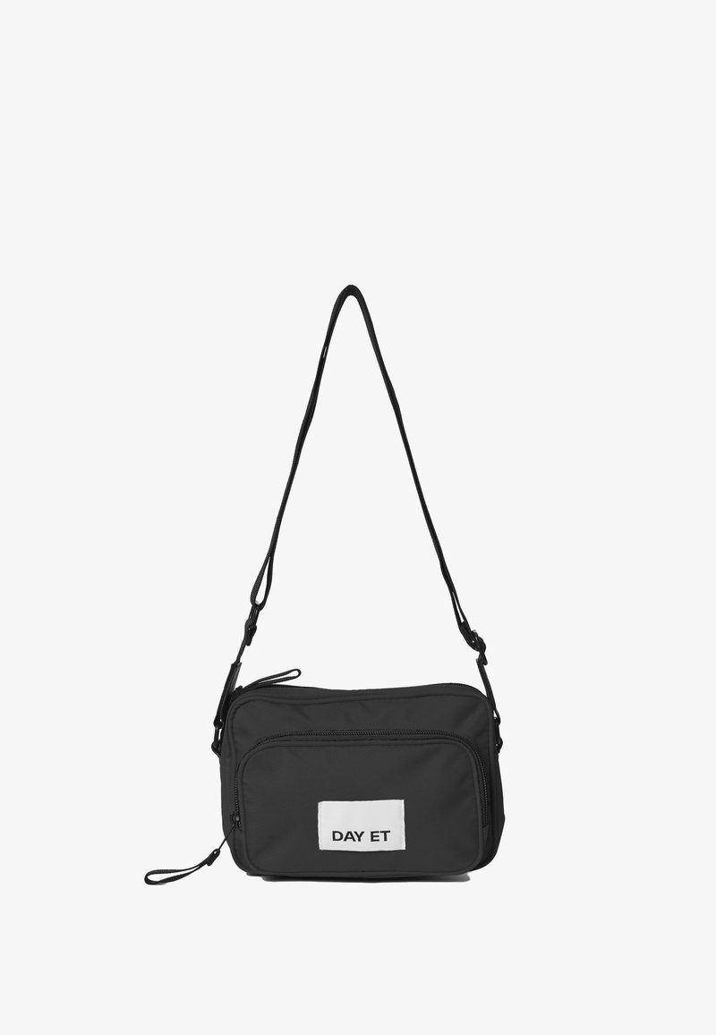 Sort nylon crossbody taske med rektangulær form, justerbar rem, to lynlåslommer og et hvidt skilt med "DAY ET" tekst.