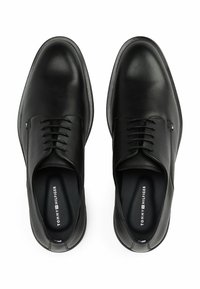 Zwarte leren dresschoenen met een gladde afwerking, ronde neus en een vetersluiting met vijf oogjes. Logo zichtbaar op de binnenzool.