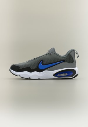 Baskets Nike gris et noir avec logo swoosh bleu et semelle à coussin d'air, vue latérale sur fond clair uni.