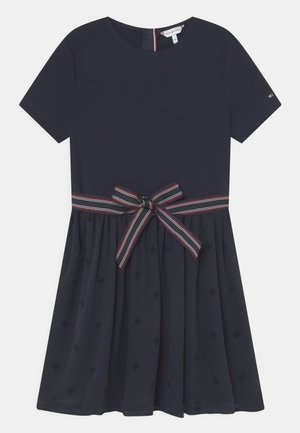 Námořnické modré šaty s krátkým rukávem, s pruhovaným páskem a decentně vzorovanou sukní.