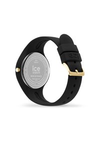 Orologio in silicone nero con design esagonale, dettagli in oro sulla fibbia e cassa in argento con incisioni. Impermeabile fino a 100m.