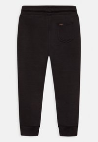 Svarta sweats med avslappnad passform, elastisk midja och ribbade muddar. Har en bakficka med ett märkesetikett. Slät textur.