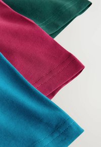 Drei Stoffstücke: Türkis, Burgunderrot und Dunkelgrün. Glatte Textur mit sichtbaren Nähten entlang der Kanten. Einfaches, ungeschmücktes Design.