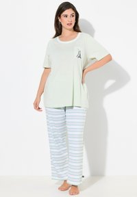 Ljusgrön pyjamasuppsättning med en kortärmad topp som har ficka och Eiffeltårn-design, tillsammans med randiga byxor i grönt och vitt.