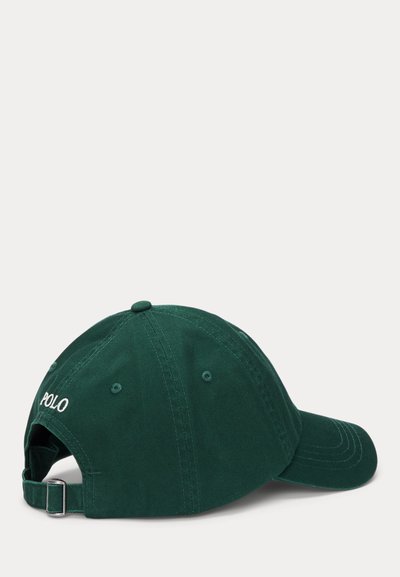 Grön bomullsbasketkeps med sydd skärm, justerbart metallspänne och broderad "POLO"-logotyp på baksidan.