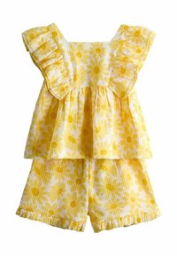 Top galben fără mâneci cu imprimeu floral, cu volane la umeri, și pantaloni scurți asortați cu volane, pentru copii, pe fundal alb.