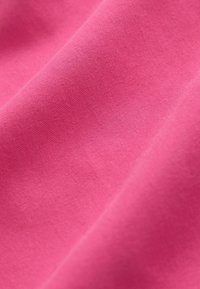 Tissu rose vif, texture lisse, surface légèrement brillante, avec une brillance constante et une subtile élasticité, présentant des plis et des froissements.