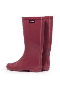 Bottes de pluie en caoutchouc rouge avec une finition brillante, hauteur mi-mollet et semelles texturées pour une meilleure traction. Présente le logo Aigle à l'avant.