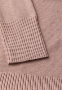 Jasnoróżowy sweter z dzianiny z prążkowanymi mankietami i dołem. Gładka faktura z delikatnymi detalami, ukazująca miękki materiał i równomierne szwy.