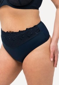 Culotte taille haute en bleu marine, en tissu doux, dotée d'une ceinture en dentelle texturée avec des motifs floraux et de côtés lisses pour plus de confort.