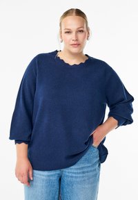 Navy blue knit sweater with a scalloped neckline and three-quarter sleeves, crafted from soft material; relaxed fit with side slits.