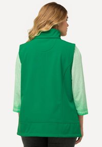Grüne ärmellose Weste mit hohem Kragen, aus glattem, leichtem Material gefertigt. Verfügt über ein schlichtes Design und seitliche Taschen.