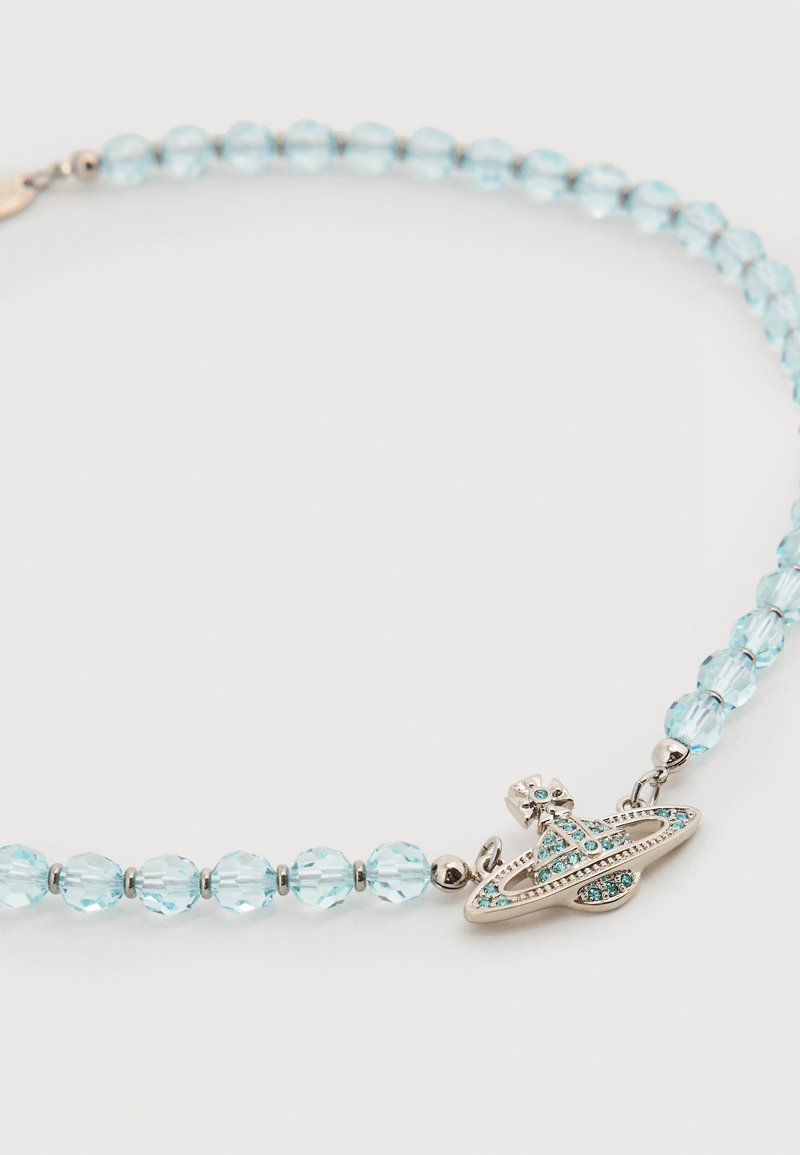 Necklace with light blue faceted beads and a silver-toned pendant shaped like a planet with rings, adorned with blue rhinestones.