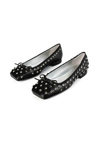 Schwarze Leder-Ballerinas mit silbernen Nieten und kleinen Schleifen auf rechteckigen Zehen, nebeneinander auf einem weißen Hintergrund dargestellt.