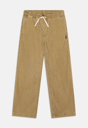 Pantalon large en velours côtelé marron clair avec une taille élastique et un cordon de serrage, ainsi qu'une petite étiquette de marque sur le côté.