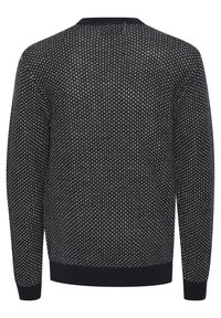 Strikket sweater med sort bund og creme dot mønstre, rund hals, lange ærmer og ribbet manchetter og kant.