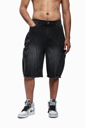 Shorts cargo en denim noir avec un ourlet effiloché, présentant des coutures incurvées et plusieurs poches, accompagnés de baskets montantes noires et grises.