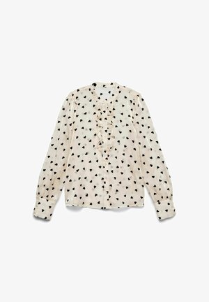 Lichtbeige blouse met lange mouwen en een rimpelvoorkant, voorzien van een zwart hartpatroon, knoopsluiting en gather-mouwen.