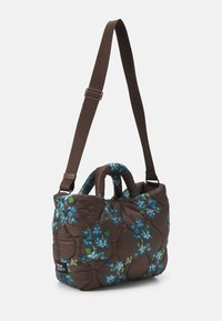 Vadderad brun handväska med blå blommönster, dubbla topphandtag och justerbar rem. Mjuk textur med tydliga sömnadsdetaljer.