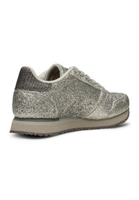 Glittrande silver sneakers med en strukturerad mörkgrå häldel, ljusgrå snören och en platt gummisula som har små greppdetaljer.
