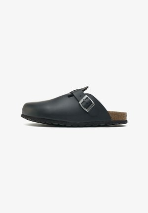 Black leather clog with a rounded shape, featuring a single adjustable strap and metallic buckle, cork footbed, and textured outsole.