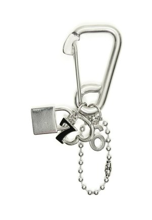 Silberner Karabiner-Schlüsselanhänger mit kleinem Vorhängeschloss, nummerierten Anhängern 7 und 6 und einer befestigten silbernen Perlenkette.