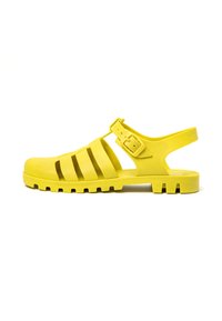 Sandalia de goma amarilla con diseño abierto, que cuenta con múltiples recortes y una hebilla ajustable. Suela texturizada para agarre y soporte.