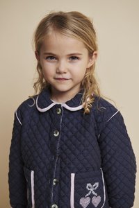 Tamsiai mėlynas dygsniuotas švarkelis su apykakle, rožiniais siūlėmis ir sagų uždarymu. Yra du priekiniai kišeniai, vienoje jų siuvinėta vyšnios piešinys.