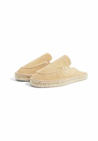 Bež suknene papuče na slip-on s pletenom jutu podlogom. Imaju zaobljen vrh i minimalistički dizajn koji naglašava glatku teksturu.