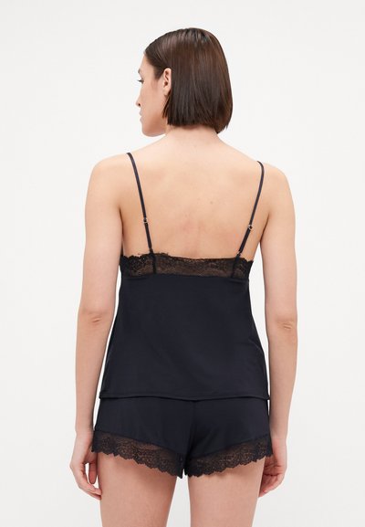 Black satin camisole with lace trim at the neckline, paired with matching shorts featuring lace hemlines. Straps are adjustable.