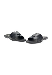 Chanclas negras con un diseño de tiras amplias y superpuestas. Hechas de material sintético mate, con una suela plana y punta abierta.