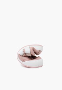 Pink and white soft-soled shoe with a rounded shape, featuring a Velcro strap and quilted texture on the upper.