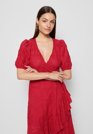 Czerwona sukienka w stylu wrap z bufkami, wzorem w oczka, głębokim dekoltem w serek oraz warstwowym detalem falbany wzdłuż dołu. Gładki materiał i dopasowana talia.