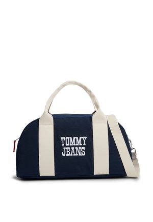 Geantă duffel bleumarin cu bretele verticale albe, text brodat „TOMMY JEANS”, mânere superioare și curea de umăr detașabilă.
