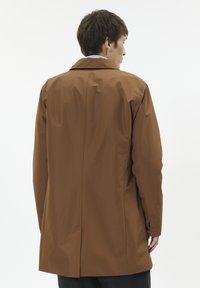 Rjav nepremočljiv plašč s klasičnim ovratnikom, elegantno obliko in dolgimi rokavi. Ima en sam zadnji razporek in gladko teksturo.