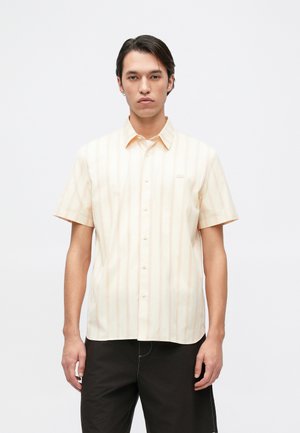 Chemise à manches courtes, jaune clair avec des rayures verticales et un logo subtil. Fabriquée en tissu lisse avec un design de col classique.