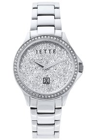Sølvtimet med en tekstureret glitrende urskive, krystalindslag på bezellet og et poleret ledarmbånd. Mærkenavnet "JETTE" er synligt.