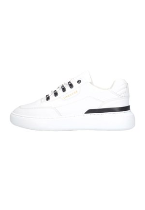 Weißer Ledersneaker mit schwarzen Ösen und dicker weißer Sohle, mit einem schwarzen Streifen nahe der Ferse und goldener Beschriftung an der Seite.
