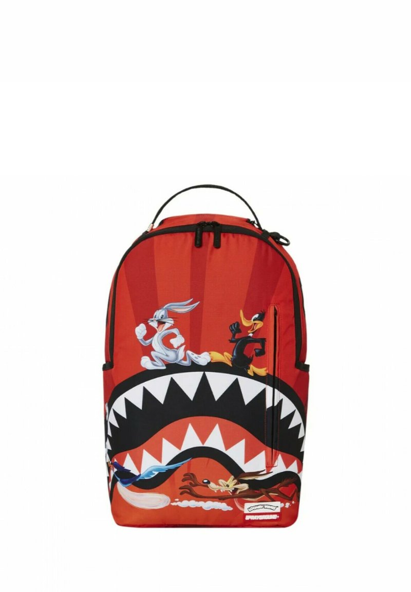 Mochila roja con un diseño de dibujos animados que presenta a Bugs Bunny y Daffy Duck. Tiene un gráfico de boca grande con dientes afilados y una textura suave.