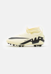 Botas de fútbol Nike Air Zoom, con una parte superior de color amarillo claro, detalles en negro, diseño aerodinámico y suela texturizada con múltiples tacos.