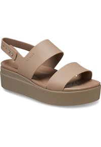 Beige platform sandalen met twee brede banden en een achterband. Gemaakt van rubber, met een gestructureerde binnenzool en decoratieve hardware.