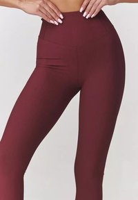 Legginsy o wysokim stanie w głębokim odcieniu burgunda, z prążkowaną teksturą i bezszwowym fasonem dla zoptymalizowanego dopasowania.