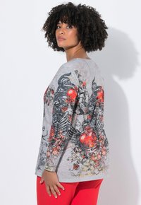 Langärmliges graues Oberteil mit aufwendigen schwarzen und roten Blumen- sowie Flügeldesigns, locker sitzend und aus weichem, strukturiertem Stoff.