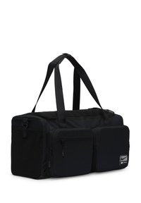 Svart sportsduffel med rektangulær form, slitesterkt stoff, to frontlommepoker med glidelås og doble håndtak for enkel bæring.