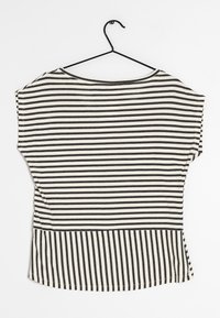 Camiseta de rayas en negro y crema, con mangas anchas, escote redondo y un dobladillo con rayas alineadas verticalmente. Textura de algodón.