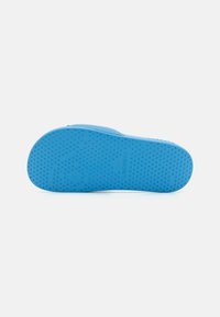 Semelle de sandale en caoutchouc bleu avec grip texturé, finition lisse et marque gravée. Bords arrondis et design de talon rond.