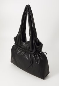 Zwarte leren handtas met een zacht,Gathered ontwerp, verlengde dubbele handvaten en een ronde basis voor een slungelige silhouet.